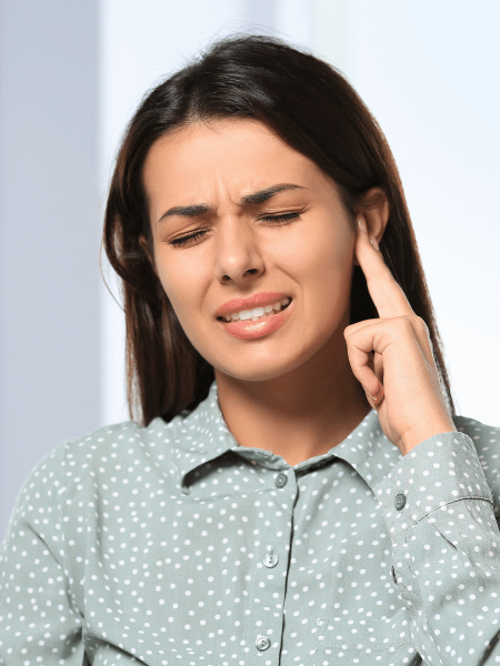 frau schmerzen tinnitus Frau hat Schmerzen am Ohr.
